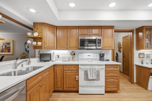 Updated Kitchen - Newer quartz countertops complement the warm oak cabinetry, with abundant workspace, generous storage, and a convenient pass-through to the living area.