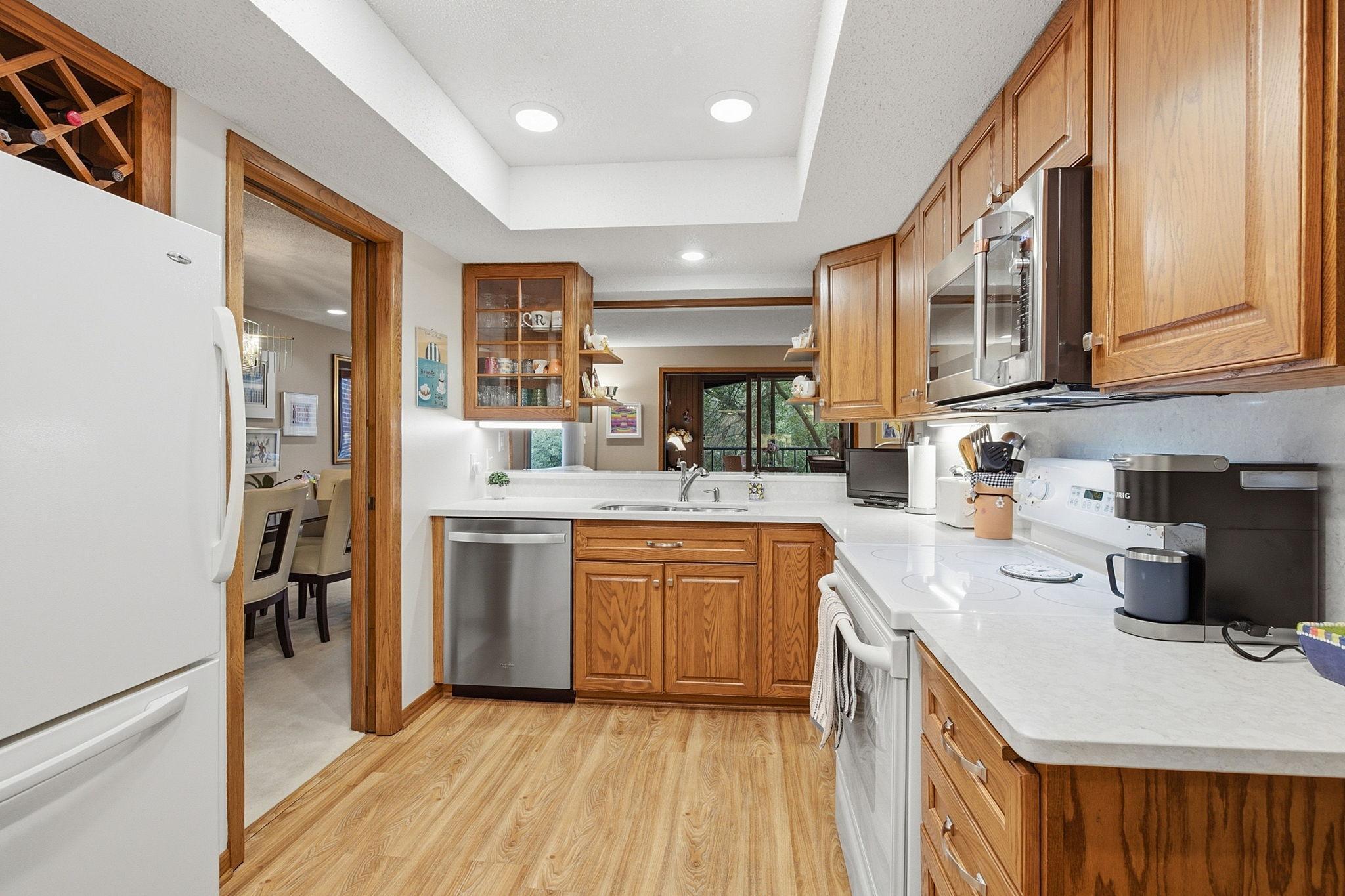 Kitchen - Functional layout features newer quartz countertops, oak cabinetry, new microwave and convection oven, recessed lighting, and ample preparation space.