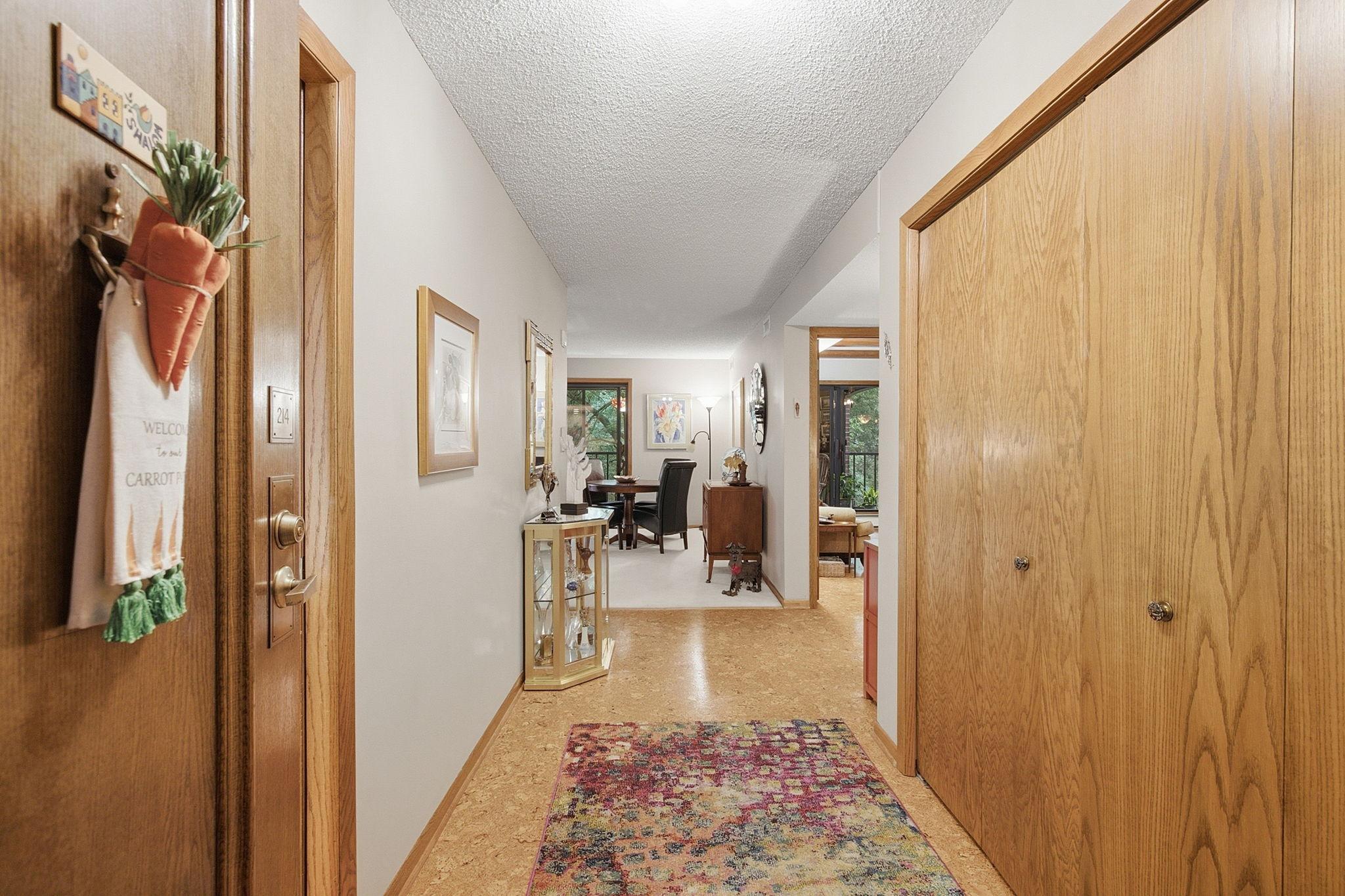 Entry Hall - A welcoming entry with warm woodwork and cork flooring leads into the home's open living spaces, with generous closet storage conveniently located nearby.