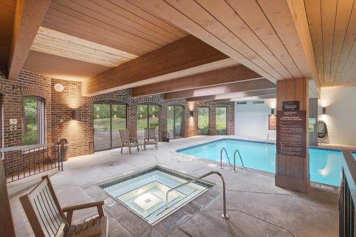 Indoor Pool & Spa - Indoor pool and spa area surrounded by large windows with views of the landscaped outdoor grounds.