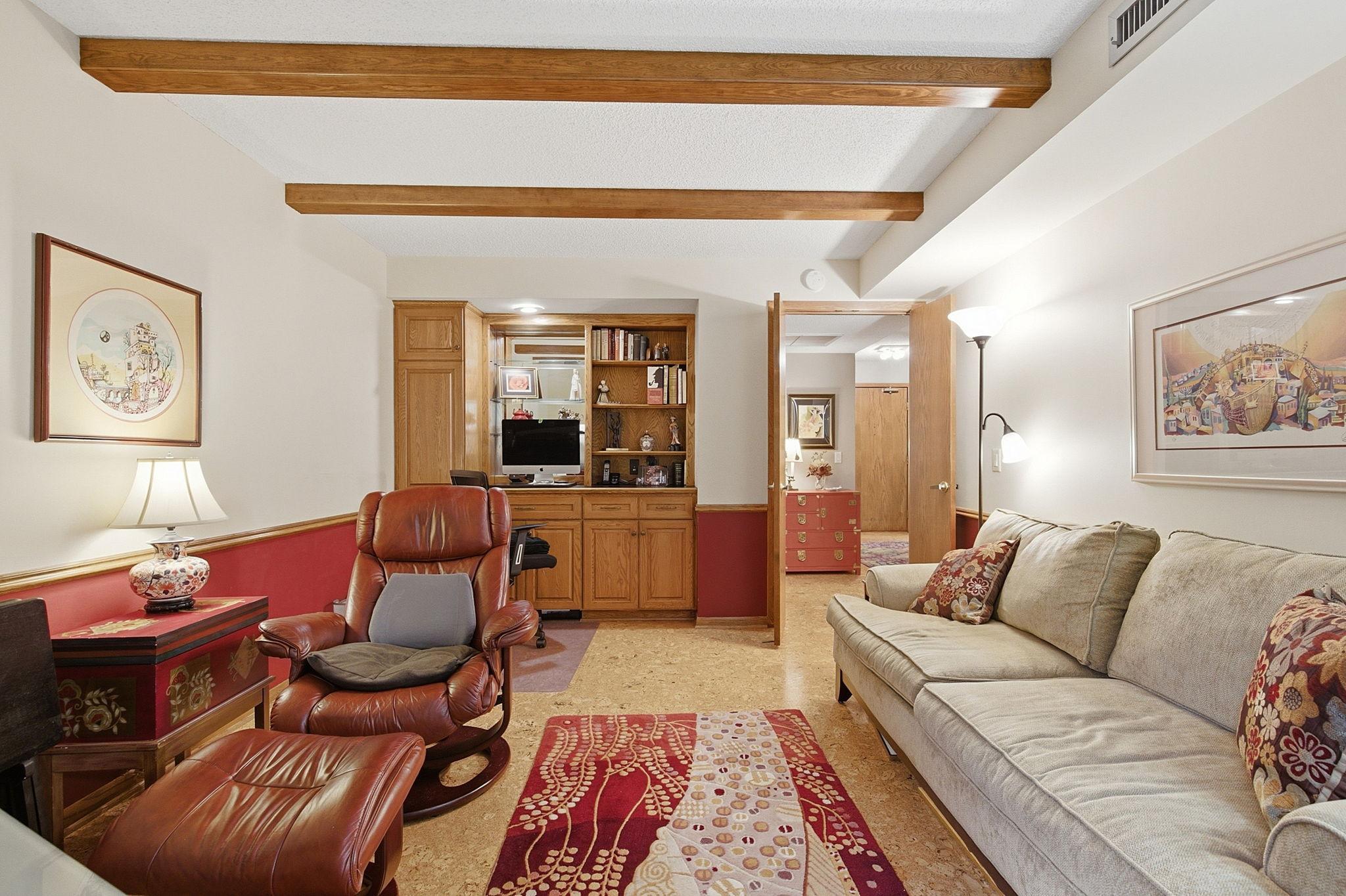 Bedroom 2/Den/Office - Another view highlights the room’s exposed beams, built-in cabinetry and workspace, warm wood accents, and flexible layout for everyday living.