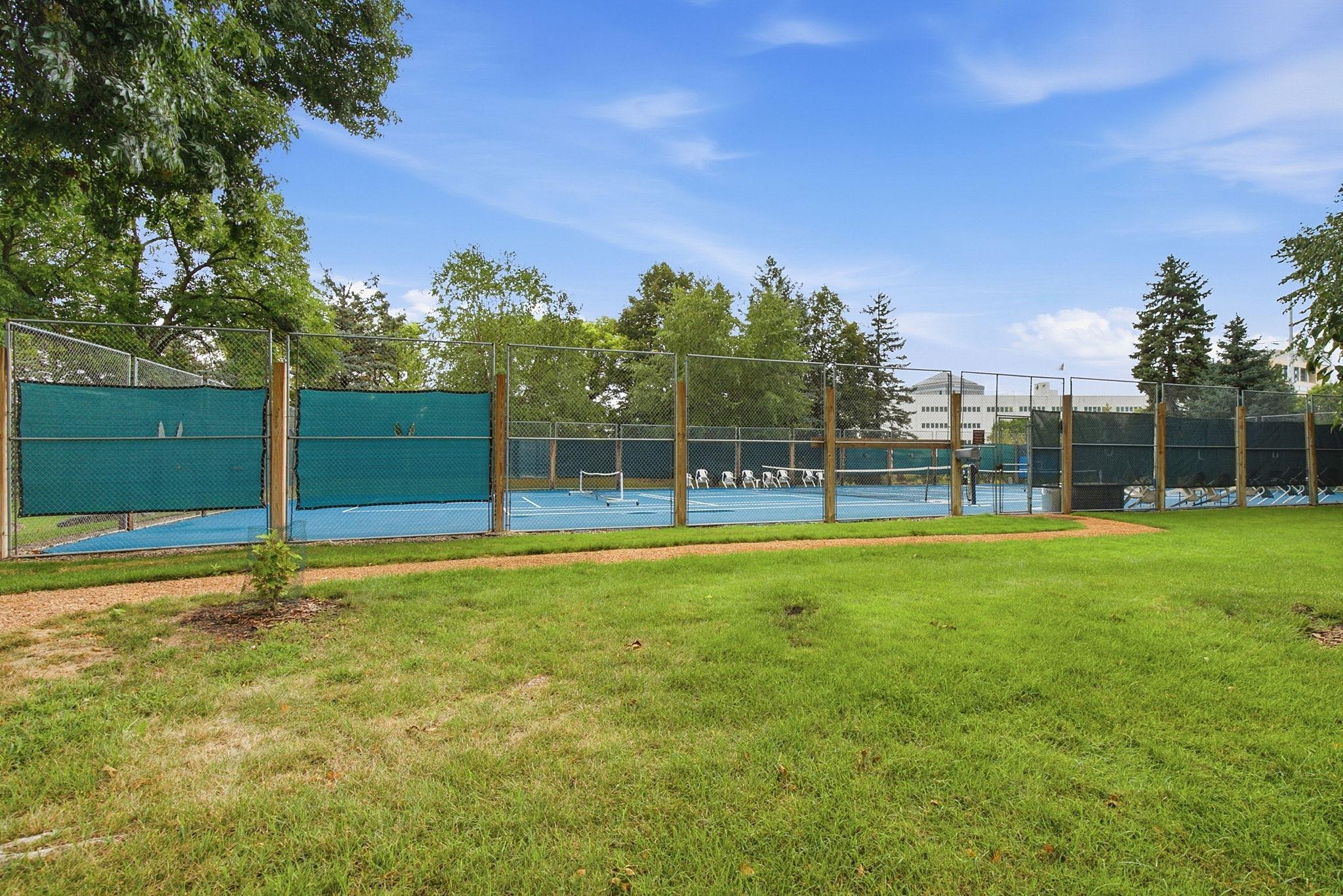 Tennis & Pickleball Courts - Enjoy outdoor recreation right at home with community tennis and pickleball courts surrounded by green space and mature trees.