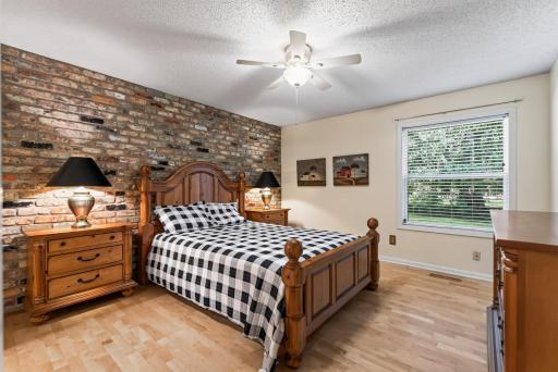 Large primary bedroom with real brick accent wall