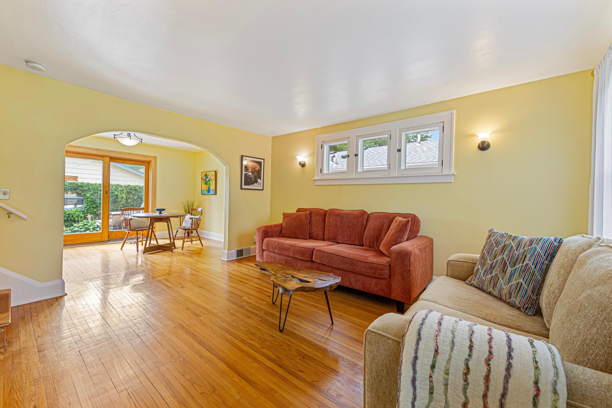 The center of the home made so inviting with a beautiful archway and gleaming hardwood floors