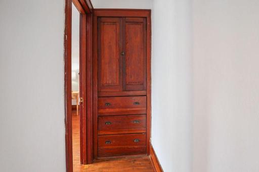 Built-in storage adds both function and vintage character just outside the bedroom.