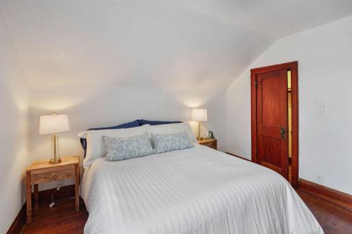 Sloped ceilings and original woodwork give this bedroom a cozy, storybook feel.