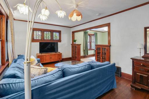 Living room showcases the home’s original character with hardwood floors, rich natural woodwork, and beautiful period details.