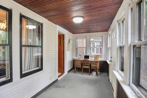 Enclosed front porch offers flexible bonus space for a sitting area, home office, or quiet retreat.