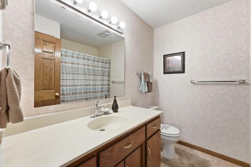 Full, private primary bathroom with a large vanity.