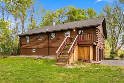 The back porch leads from the kitchen down to the large yard with storage underneath