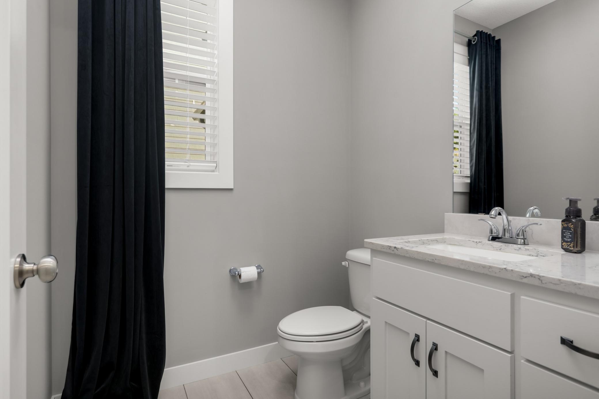Main-level powder room with bright finishes and a clean, contemporary design.
