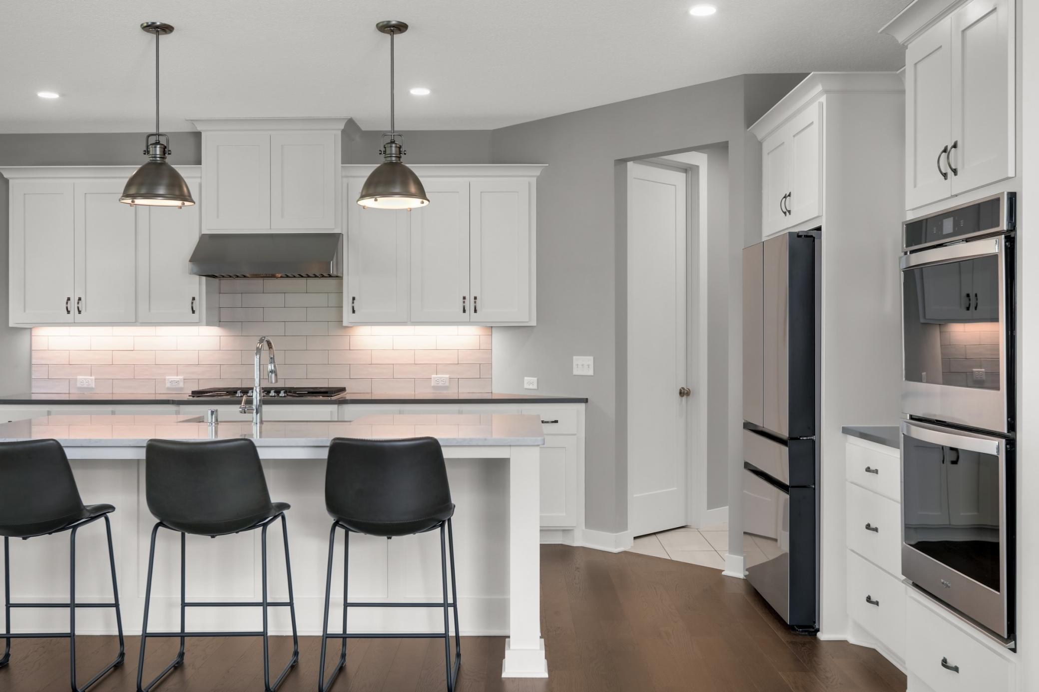 Beautiful kitchen with a large center island, farmhouse-style sink, stainless steel appliances, and generous workspace.
