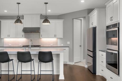 Beautiful kitchen with a large center island, farmhouse-style sink, stainless steel appliances, and generous workspace.