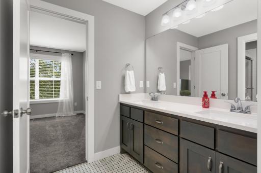 Jack-and-Jill-style bathroom features a long dual-sink vanity and excellent storage.