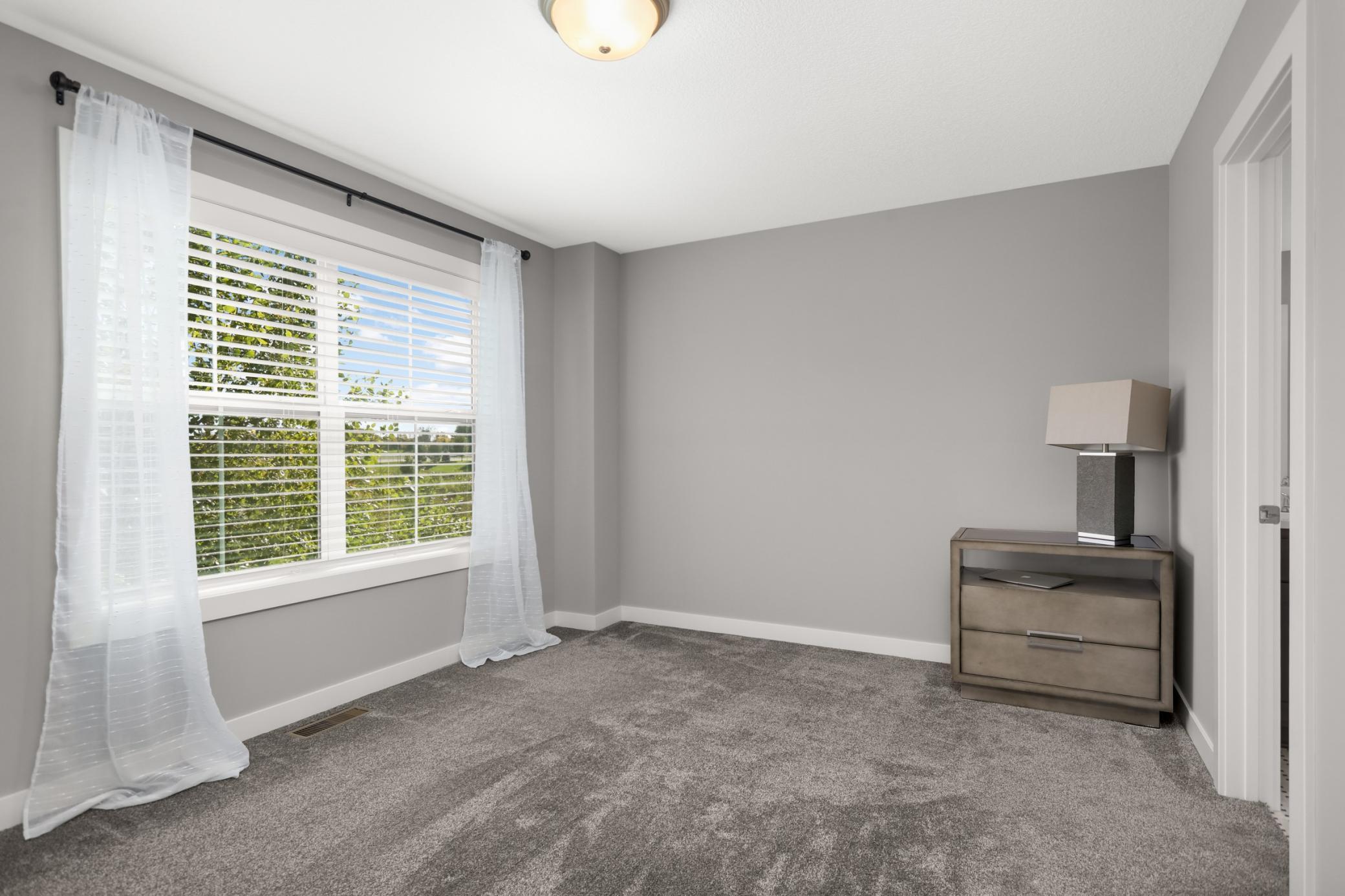 Additional upper-level bedroom with a large window and abundant natural light.