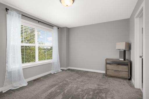 Additional upper-level bedroom with a large window and abundant natural light.