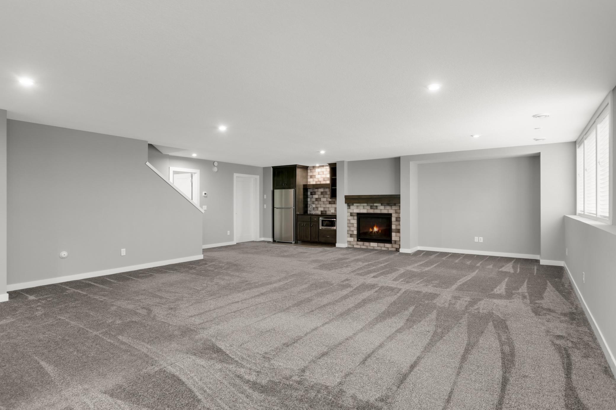 Bright lower-level family room features multiple windows, recessed lighting, and plenty of open living space.