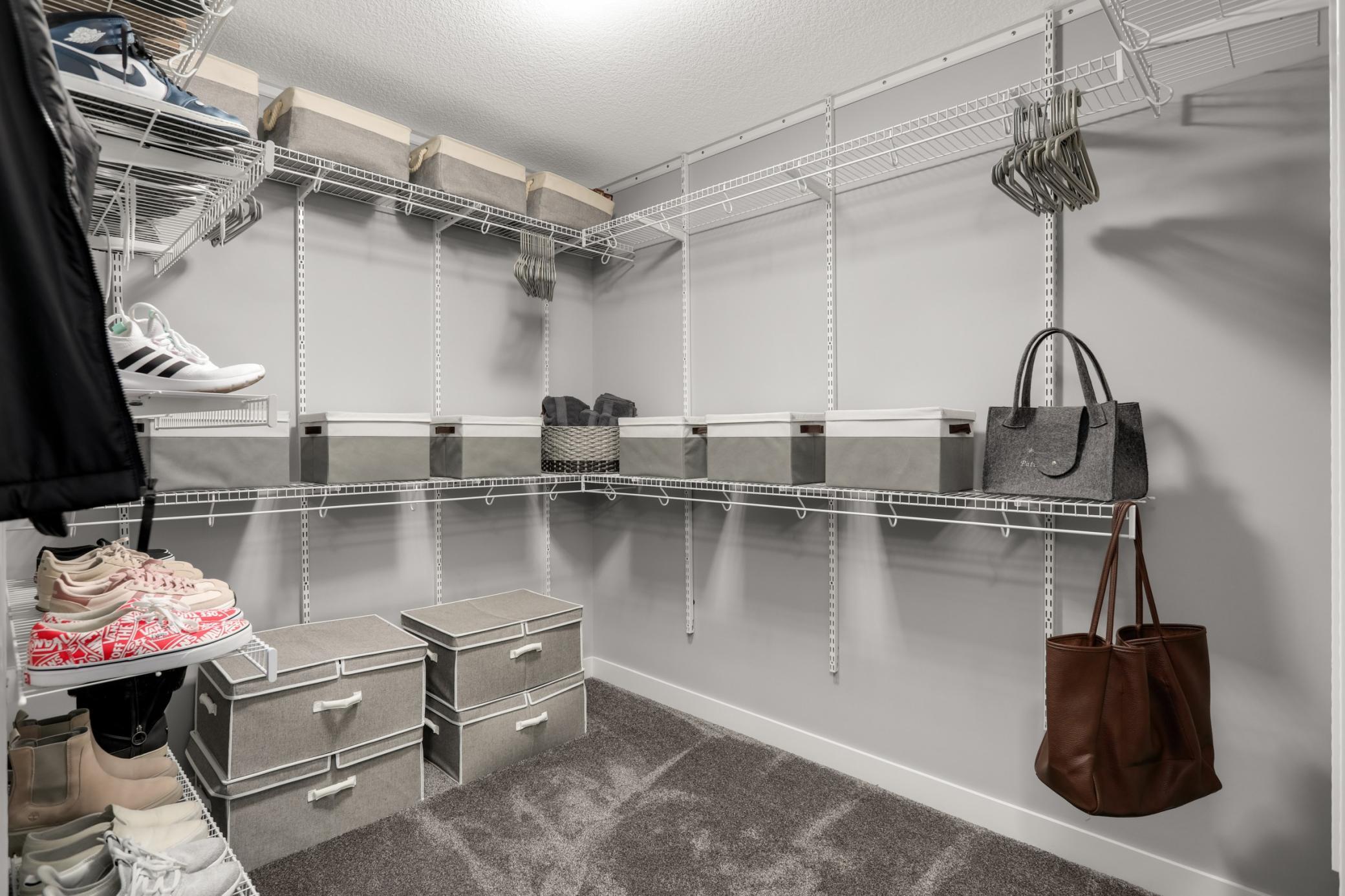 Large walk-in primary closet provides extensive shelving and hanging space.