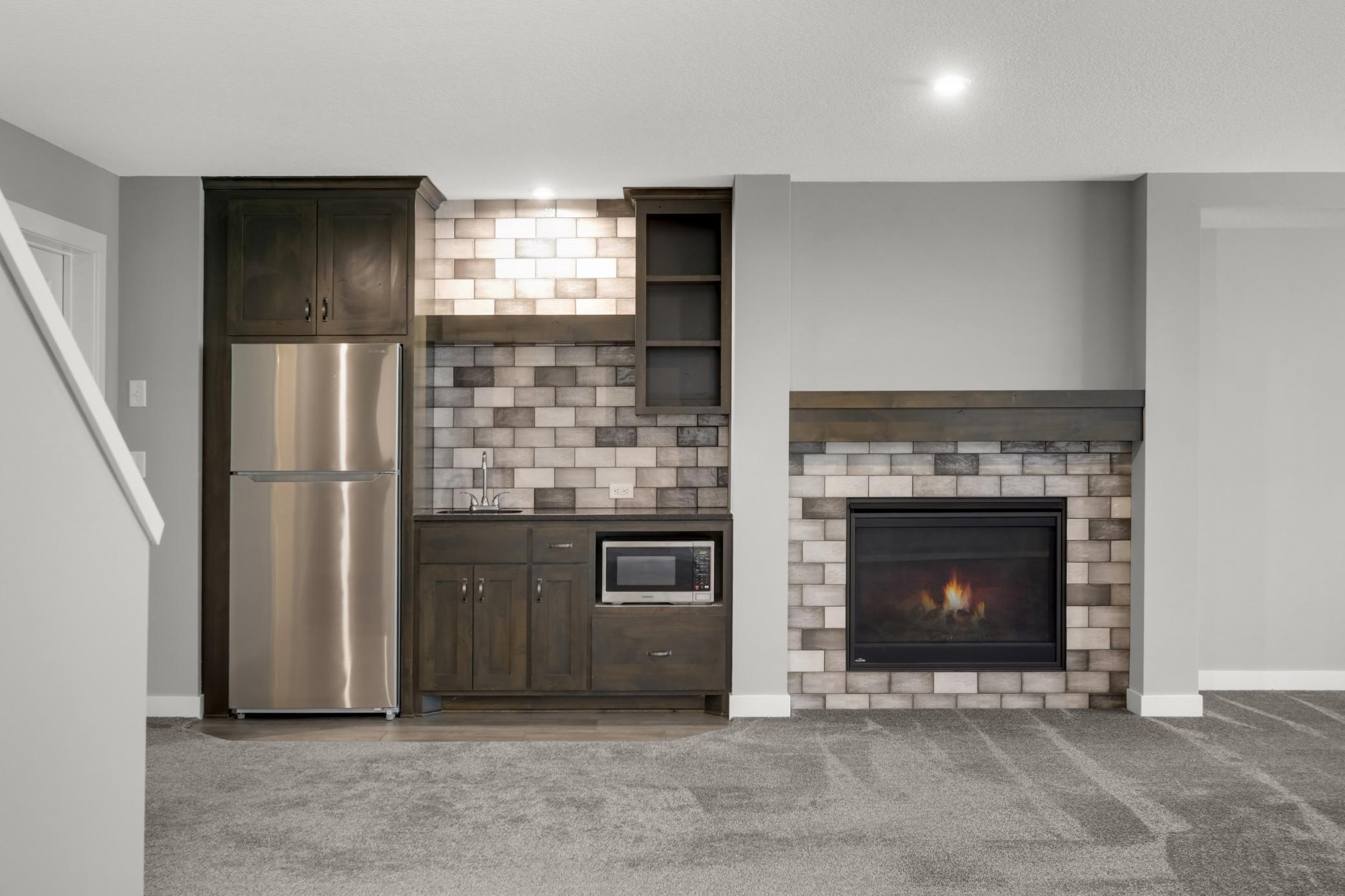 Large recreation room includes a fireplace and built-in bar area for effortless entertaining.
