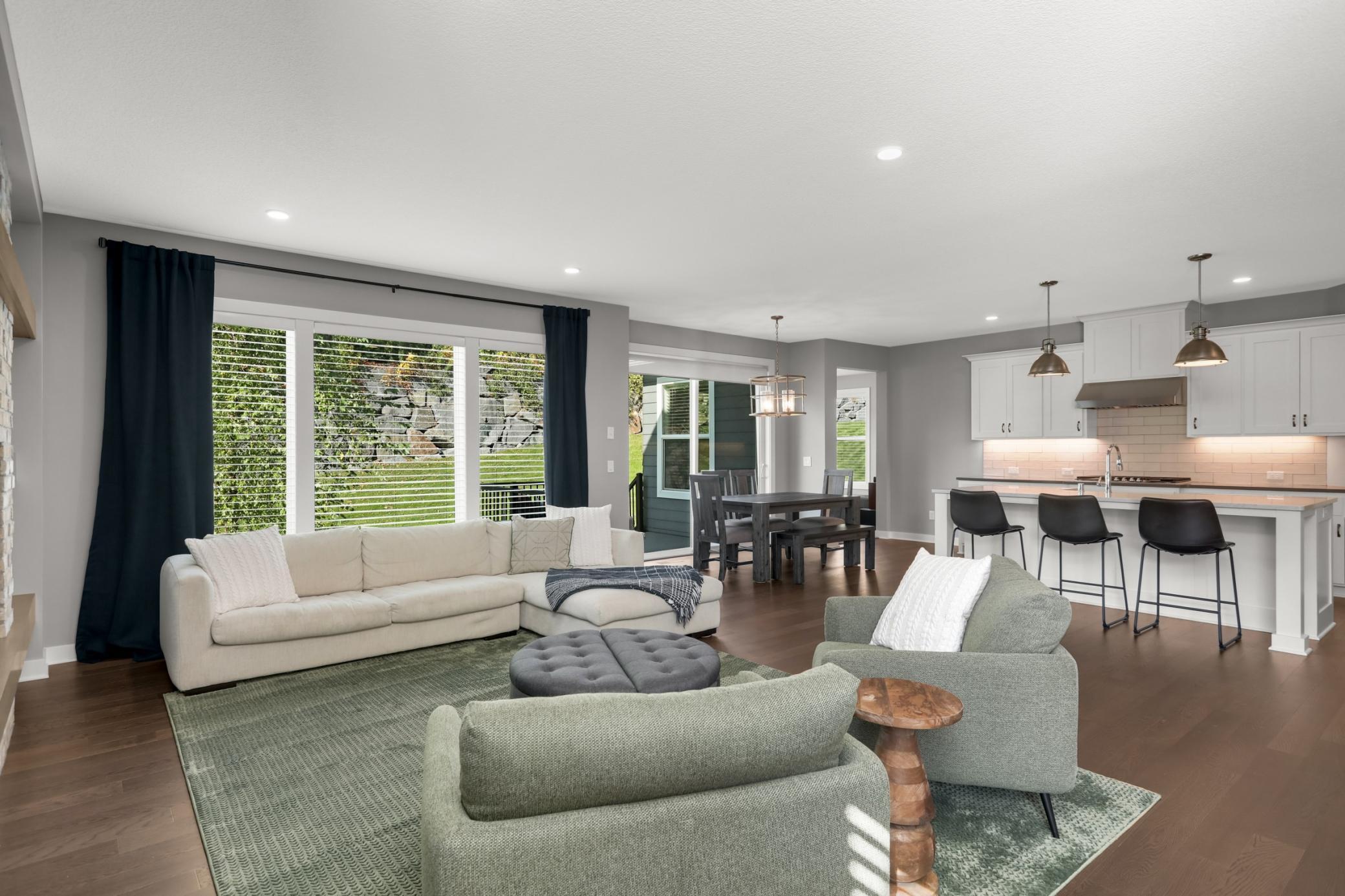 Bright living room with oversized windows, abundant natural light, and a beautiful fireplace focal point.