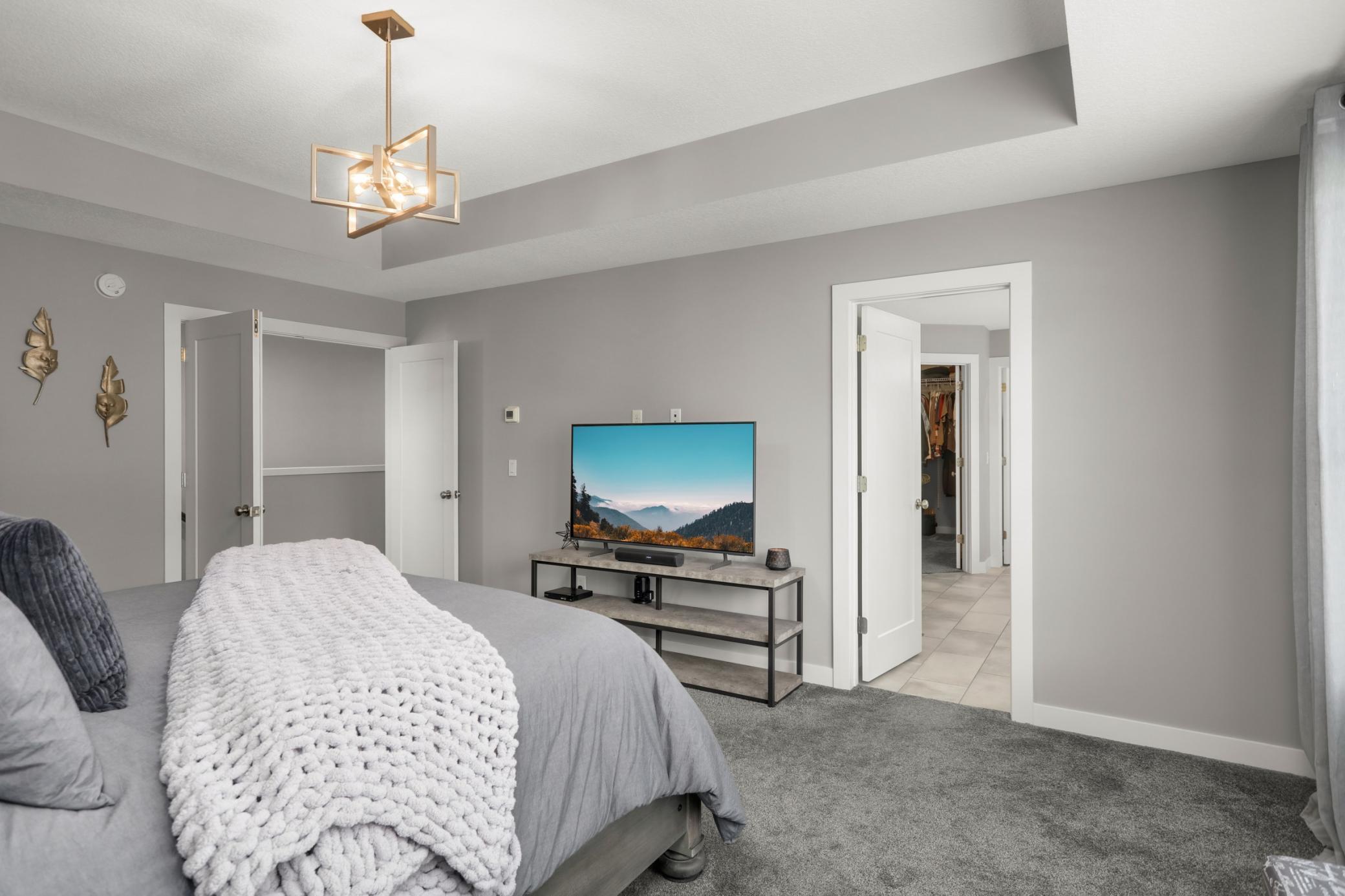 Another view of the primary bedroom highlights its spacious layout and private ensuite access.