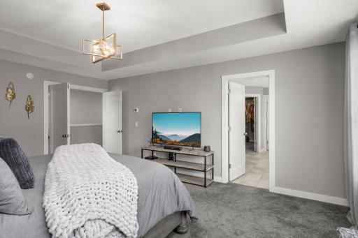 Another view of the primary bedroom highlights its spacious layout and private ensuite access.