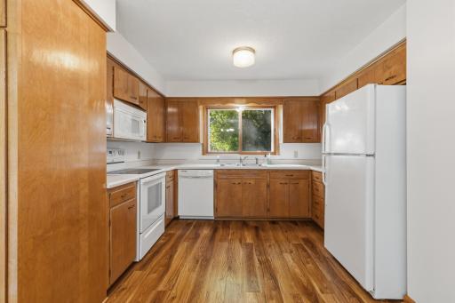 The bright kitchen with all the appliances (microwave, oven/range, dishwasher, and refrigerator).