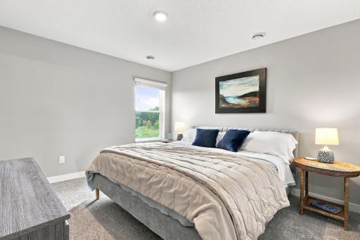 Upper level primary bedroom with ensuite bathroom and walk in closet. Bedroom overlooks the backyard which looks over the wetlands