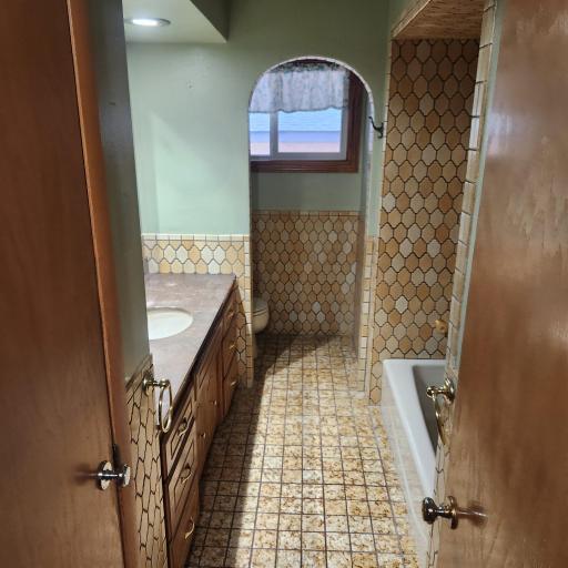 Full tile bath with separate toilet area.