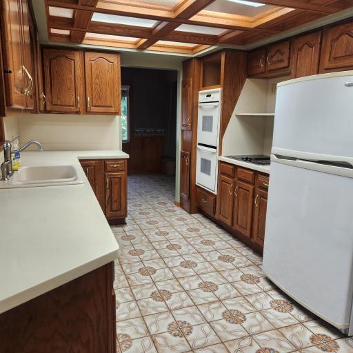 Custom Raised Oak cabinets, hard surface tops, tile flooring and built-in Appliances.