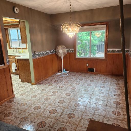 Dining room with tile flooring that carries through from the kitchen, buil-in features glass doors and 2 walls of windows.