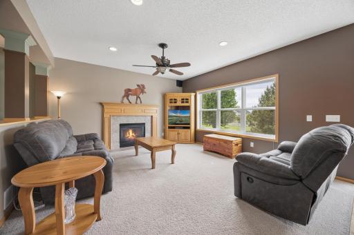 Relax and unwind in the spacious family room, featuring a cozy gas fireplace and large windows that frame peaceful backyard views. A welcoming space for movie nights, quiet evenings, and gathering with family and friends.