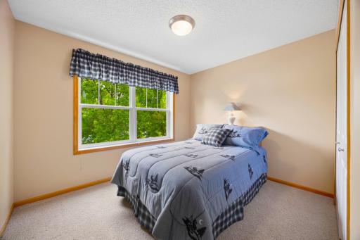 Bedroom #2 offers a bright and inviting retreat with large windows that fill the space with natural light. A comfortable and versatile room with plenty of potential for a guest suite, bedroom, home office, or personal retreat.