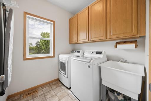 Convenient main-level laundry room and utility sink has newer washer and dryer (2019), plus plenty of storage