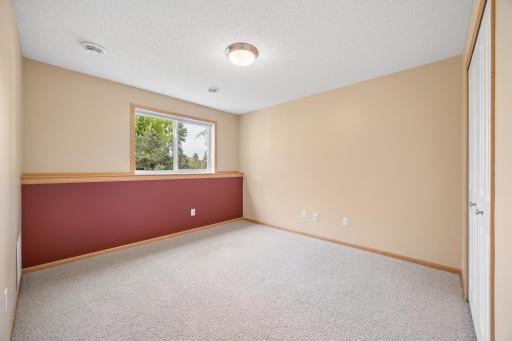 Perfect for guests, this lower-level 4th bedroom offers a comfortable retreat with great closet space and convenient access to a full bathroom—providing privacy and flexibility for overnight visitors, family, or a home office, or workout area.