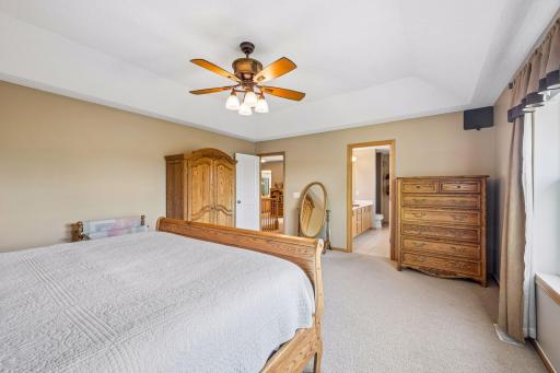Primary bedroom offers generous space to relax from the day, including a sitting area and private primary bathroom suite access