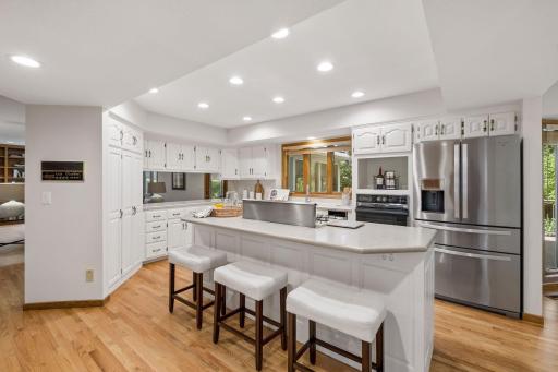 Expansive kitchen is loaded with cabinetry, walk in pantry, and countertop seating