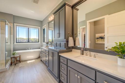 Luxurious primary bath features a double vanity, soaking tub, and beautifully tiled shower!