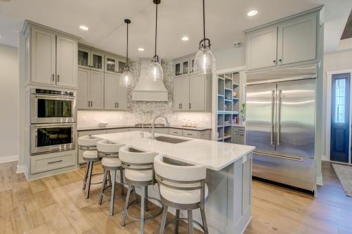 The gourmet kitchen blends style and function with beautiful quartz countertops, stainless steel appliances, and a stunning tile backsplash!