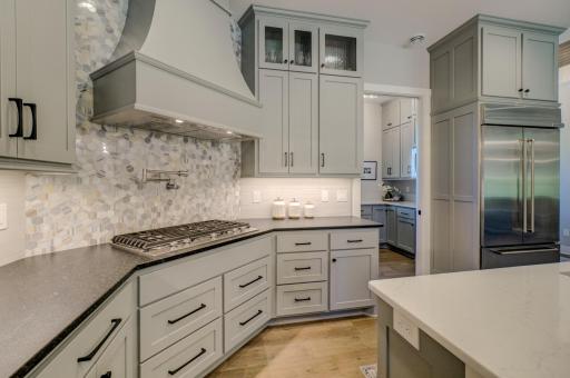 Effortless cooking meets refined style in this gorgeous kitchen, featuring a sleek cooktop and convenient pot filler faucet!