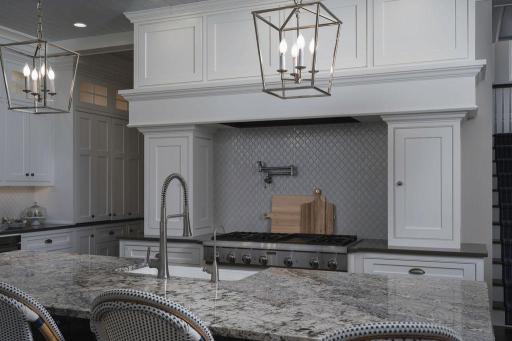 Beautiful hard surface counter tops and top of the line appliance package and stunning white cabinets.