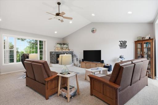 Vaulted Great Rm features gas fireplace w/tile surround, huge windows provides lots of natural light, built-in rear spkrs + ceiling fan/light (remote) + updated carpet