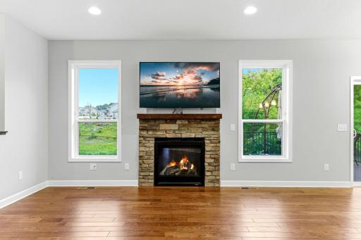A sleek gas fireplace wrapped in a beautiful stone surround that adds texture, warmth, and modern character to the room.