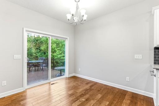 Bright dining space featuring a sliding glass door that opens directly onto a charming deck creating a seamless indoor-outdoor connection