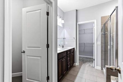 Beautiful primary bath featuring dual sinks, a separate soaking tub and walk-in shower, a private toilet closet, and direct access to the spacious walk-in closet.