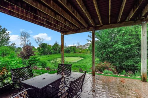 A peaceful lower-level patio with a serene view of the pond, offering a quiet outdoor retreat perfect for relaxing, entertaining, or enjoying nature right from home.