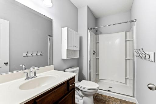A clean and modern 3/4 bath on the lower level featuring a bright shower, fresh finishes, and convenient access from the family room and fourth bedroom