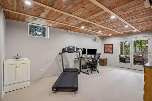 The 4th bedroom on the walkout level is used as an office/workshop. It opens to the large storage closet as well as the breezy screened porch. It also has a utility sink and built-in cabinetry on one wall.