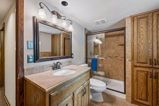 A lovely 3/4 bath is conveniently located near the bedoom and office. It features a large walk-in shower with glass doors, generous vanity, built-in storage and updated lighting and fixtures.