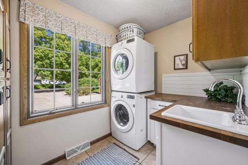 A handy main floor laundry is conveniently located near the bedrooms wing. There is additional cabinetry and storage, large front load washer and dryer, as well as a handy utility sink.